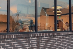 A street view shop of the window that looks into the bakery kitchen.