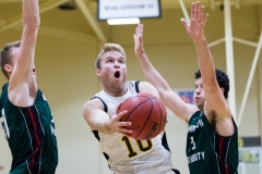 Mason Hankins slides throw two defenders to score a layup during the Tigers 77-84 loss to Washington University in St. Louis Saturday night. SAM CARAVANA / THE DEPAUW