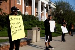 Juniors Jayla Rufus (left) and Caesar Tobar- Acosta (center) hold signs in protest outside of the Union Building. Students of color silently protested at a family weekend event on Saturday morning. SAM CARAVANA /THE DEPAUW