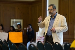 President McCoy addresses a crowd of parents while behind him students of color hold signs. SAM CARAVANA / THE DEPAUW