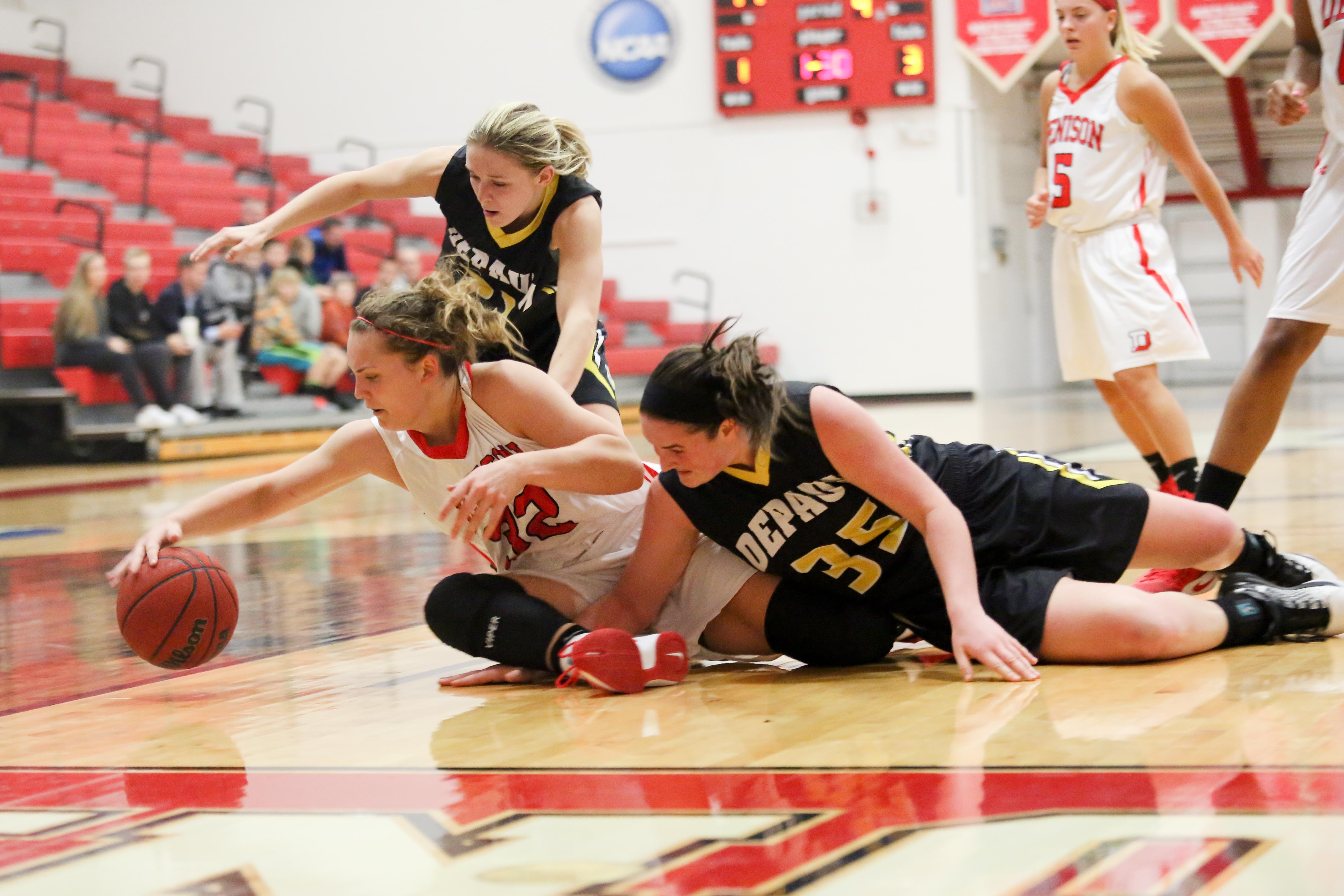 Claire Ryan (left), Lauren Hofer (center), and Melinda Franke (right) dive after a loose ball. DePauw continued its 12-game winning streak topping Denison 63-50 in double overtime. SAM CARAVANA / THE DEPAUW