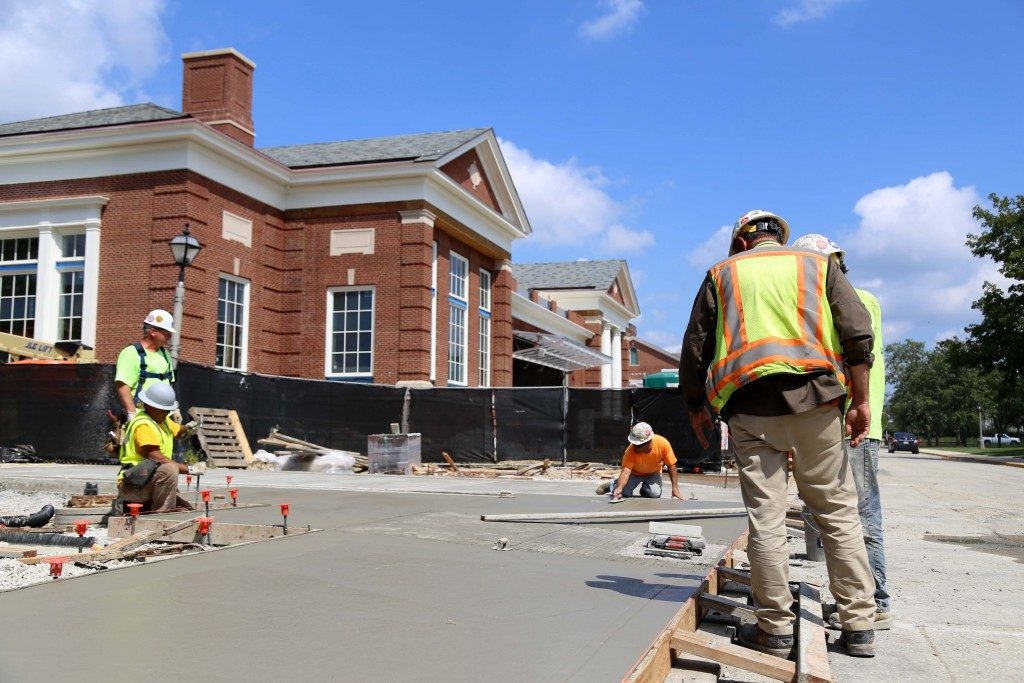 Construction workers replace a sidewalk on the corner of Hanna St. and South College Ave near Hoover Hall. Hoover Hall is expected to officaly open November 1.  SAM CARAVANA / THE DEPAUW
