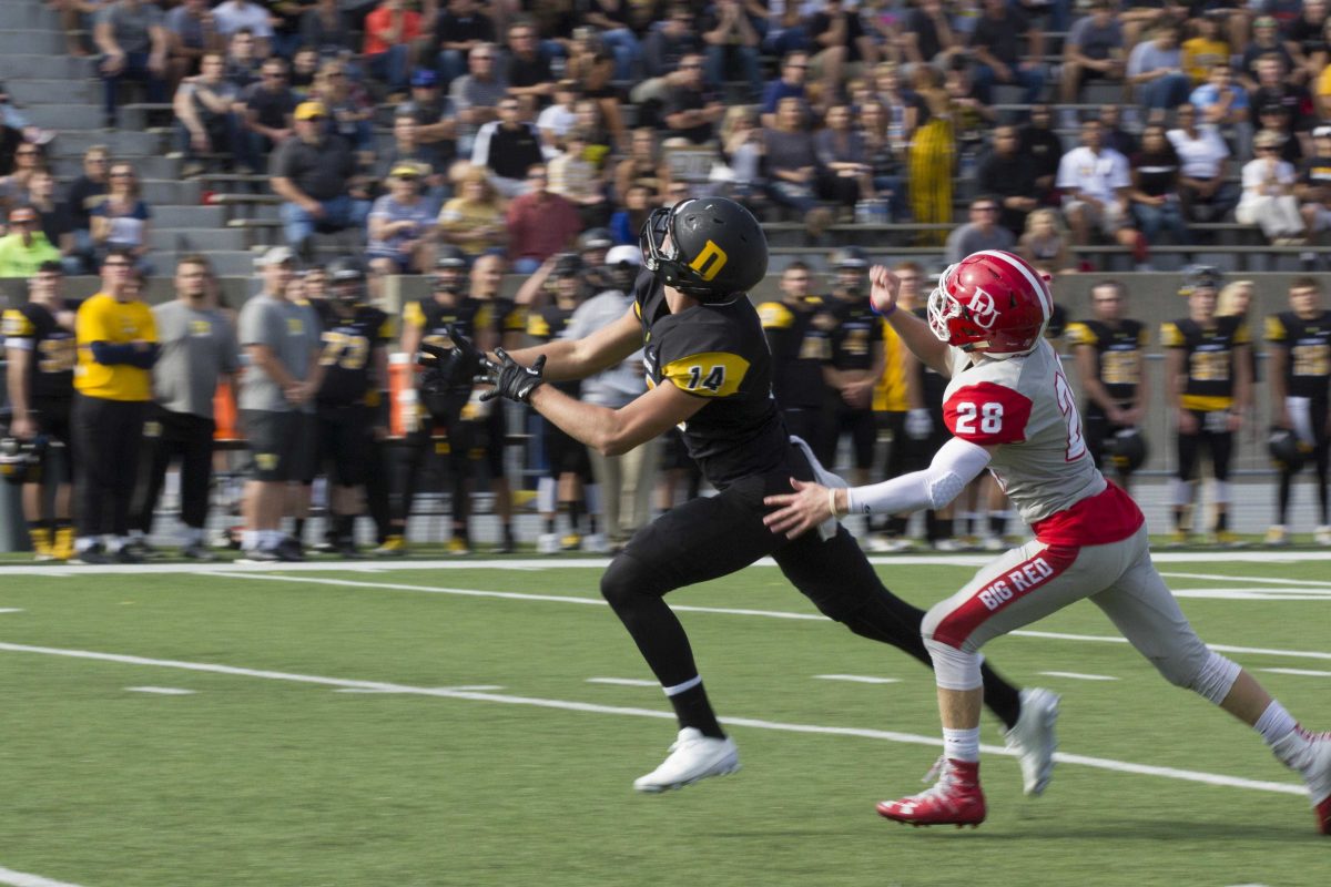 Junior Ben Wilson attempts to make a completion with Denison defender Lucas Gunkel all over him. ZACH TAYLOR / THE DEPAUW