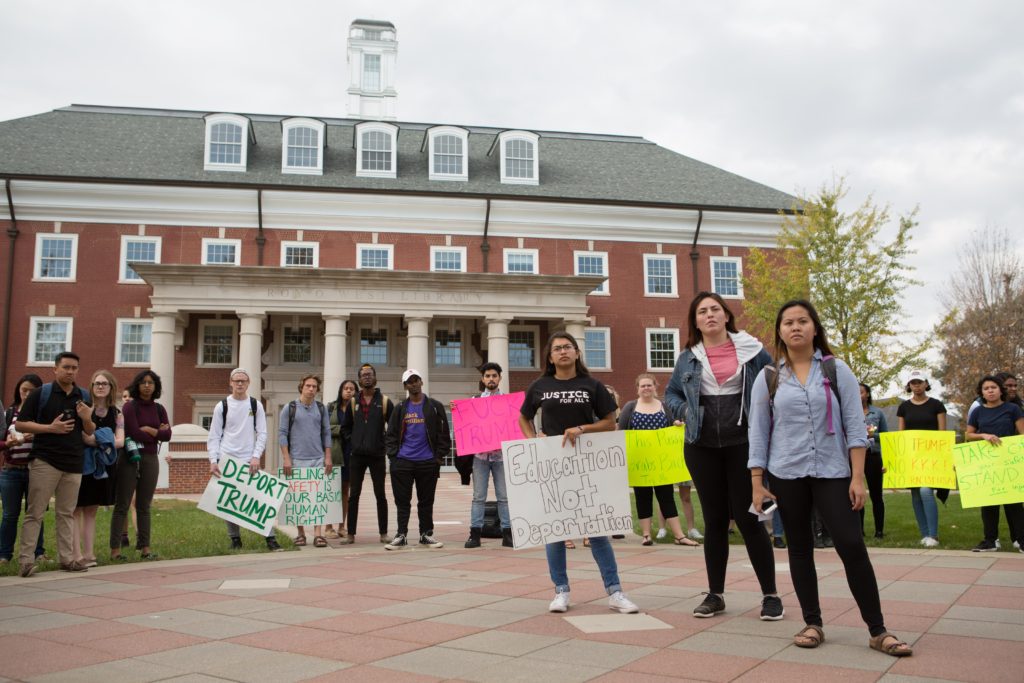 Junior Maggie Rocha and seniors Jackie Rueda and Nancy Huynh (left to right) stand in the middle of a circle of protesters. The trio led the demonstration and demanded a meeting with the administration by Nov. 30 to talk about making DePauw a sanctuary campus. SAM CARAVANA / THE DEPAUW