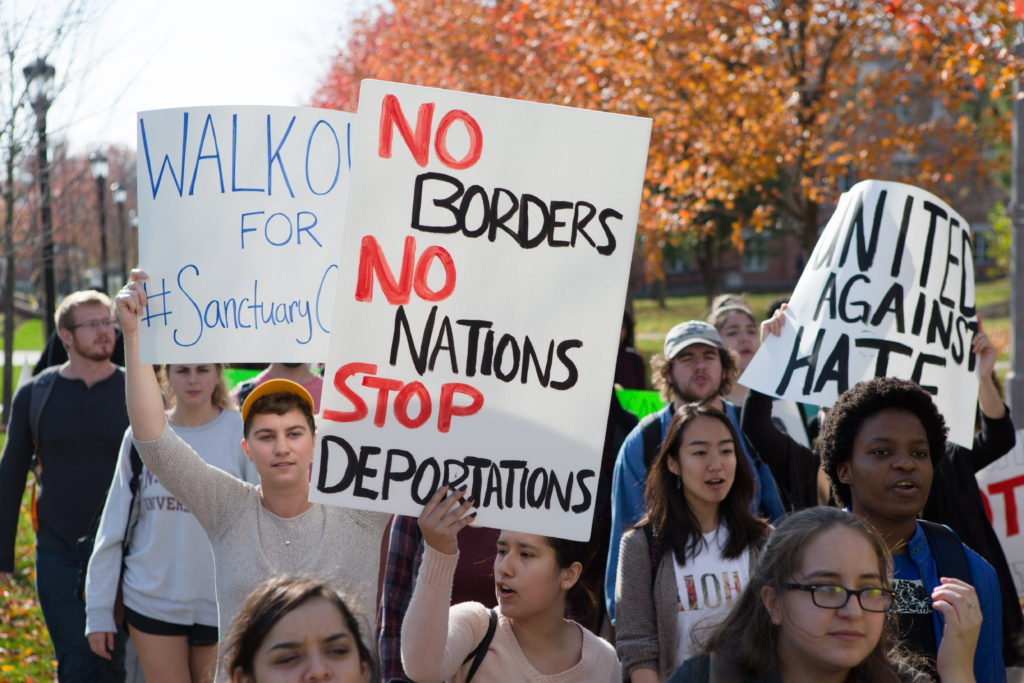 Students hold up signs as they chant and march through the center of campus Friday afternoon. The demonstrators demanded a meeting with the the administration by Nov. 30 to talk about making DePauw a sanctuary campus. SAM CARAVANA / THE DEPAUW