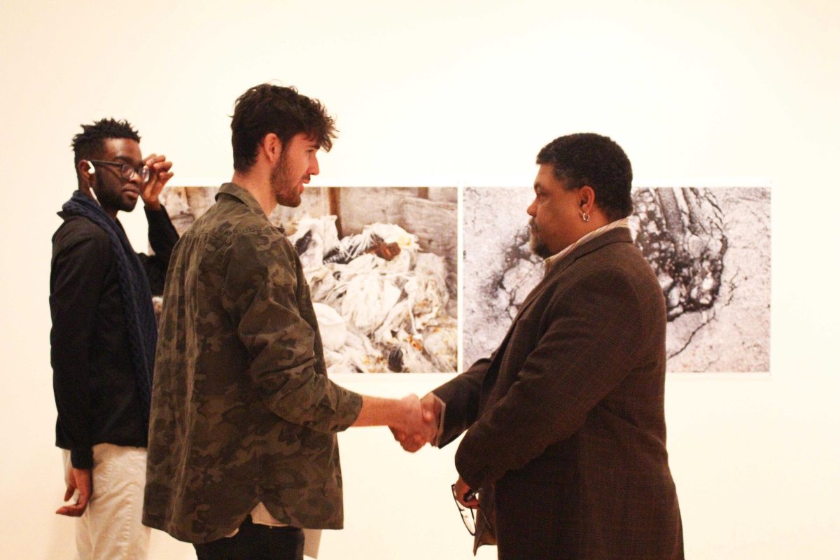 Malcolm Mobutu-Smith (right center) talks with two-dimensional second prize winner, Kerrigan Clark (left center), about his work. DAVID KOBE / THE DEPAUW