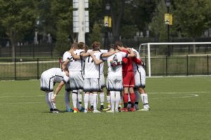 The Men's Soccer team huddles up before heading into overtime. REID COOPER