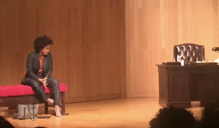 Actor, Ayanna Bria Bakari playing the main character of Cat, speaks to an off stage Antonin Scalia next to the only set design of the play. THE DEPAUW CHARLIE SORRELLS