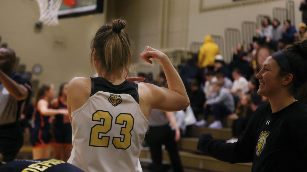 Image of Riley Mont ‘26 (#5) shooting while being guarded by a Hope College opponent. 